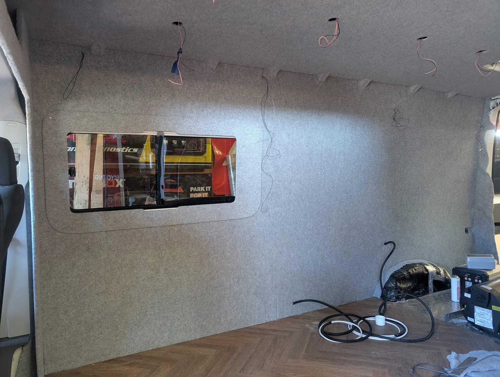 Bare ply-lined campervan wall before carpeting